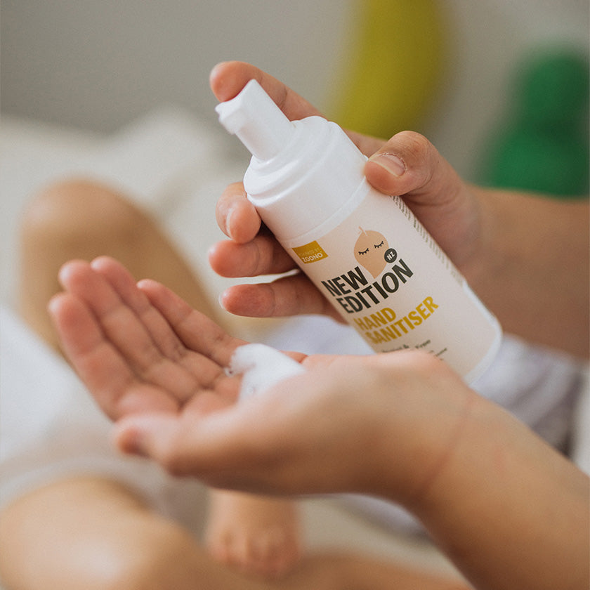 close up photo of mum Mum using the foaming adult hand sanitiser to kill germs and clean hands after changing dirty nappy 