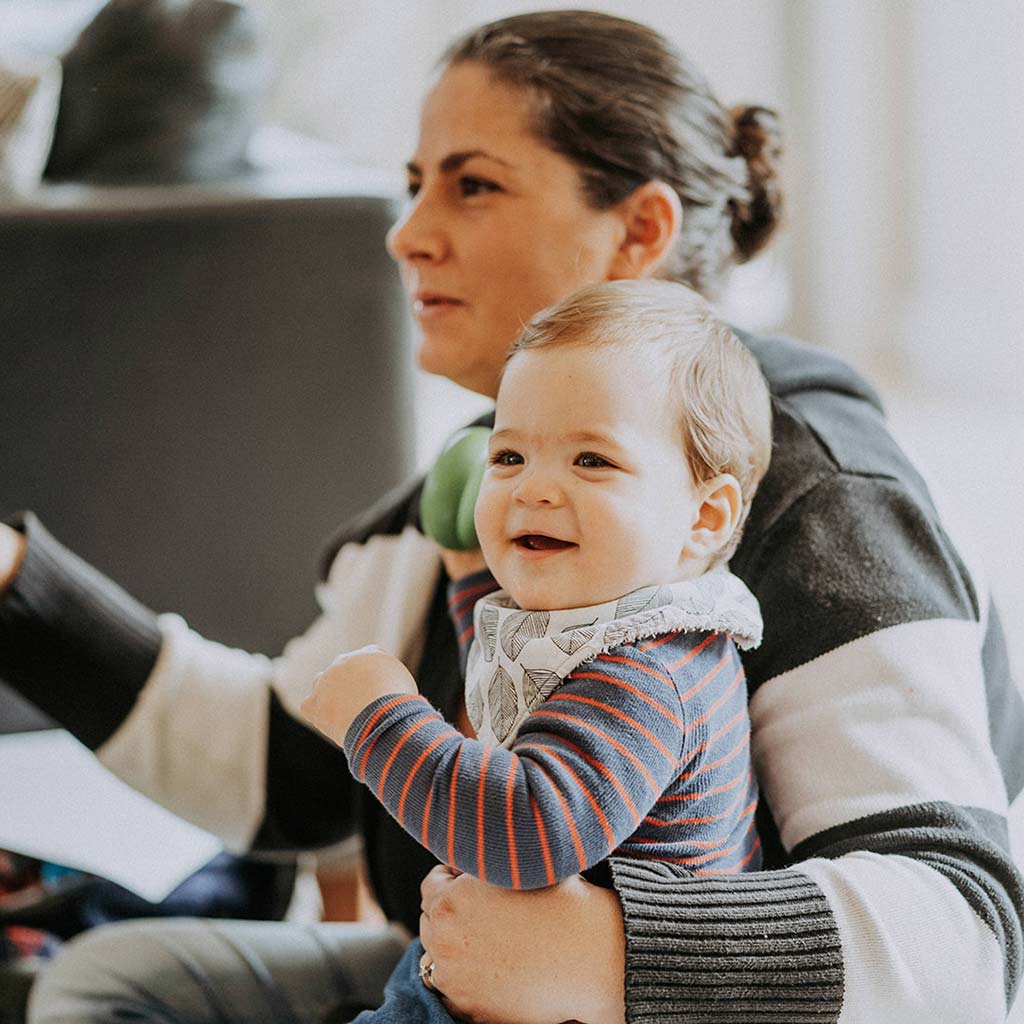 Mum holding toddler and smiling