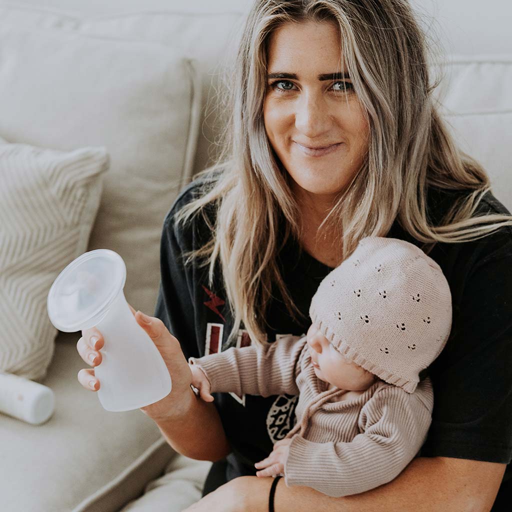 Mum holding her daughter while smiling at the camera 