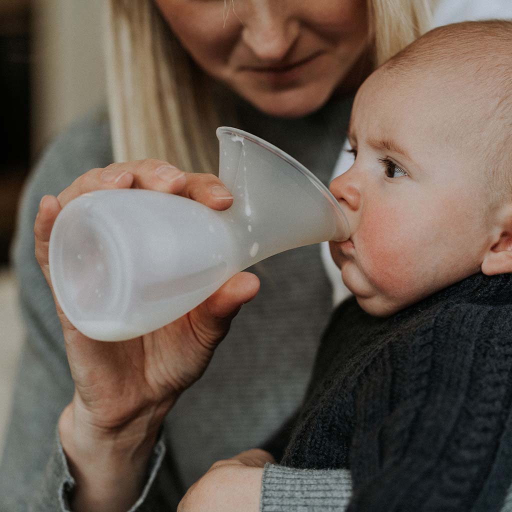 Mum feeding her baby breast milk straight from the Pumpd Breast Pump