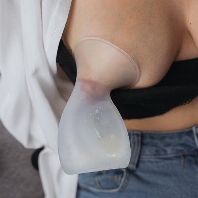 close up photo of mum using the Pumpd manual breast pump on her breast to collect breast milk. it is hands free and does not require power or batteries